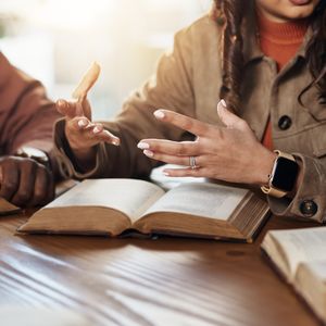 People talking in front of Bibles