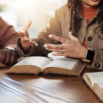 People talking in front of Bibles