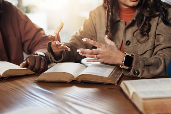 People talking in front of Bibles