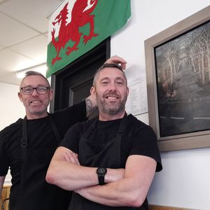 Adrian and Martin Shaw from the Busy Teapot in Penarth with a painting entitled 'Takes Cross'