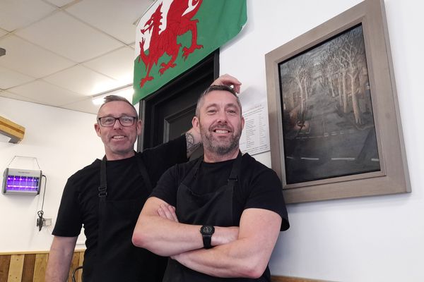 Adrian and Martin Shaw from the Busy Teapot in Penarth with a painting entitled 'Takes Cross'