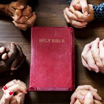 Bible and hands clasped