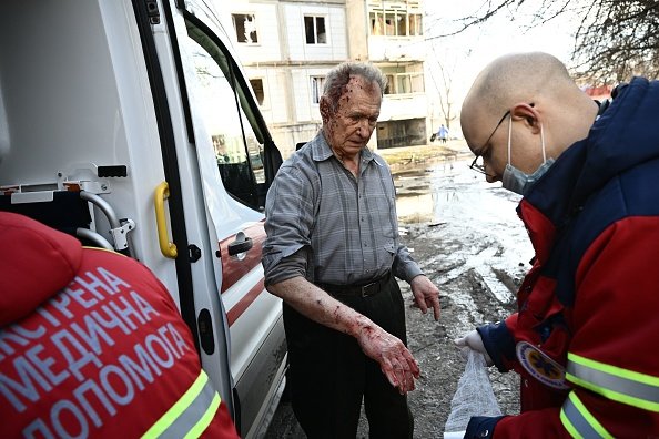 Emmergency unit staff treat an injured man after bombings on the eastern Ukraine town of Chuguiv. (Photo by ARIS MESSINIS/AFP via Getty Images)