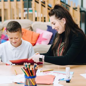 A teacher and child creating art