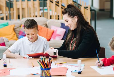 A teacher and child creating art