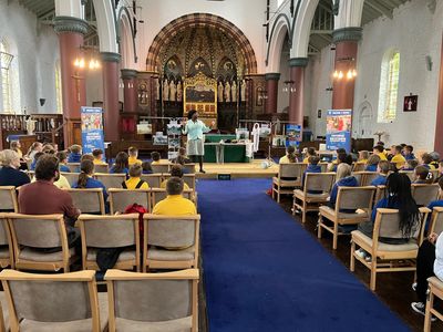 Schoolchildren watch a play about Betty Campbell at St Mary's Church, Butetown